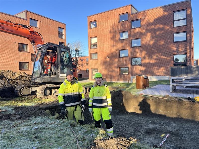 To arkeologer graver i en sjakt foran ett av byggene på Moholt studentby.