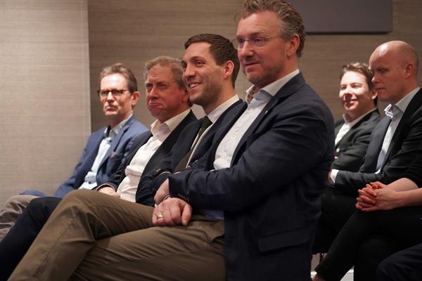 Fylkesordfører, klima- og miljøminister med flere sitter på rekke og ser mot scenen.