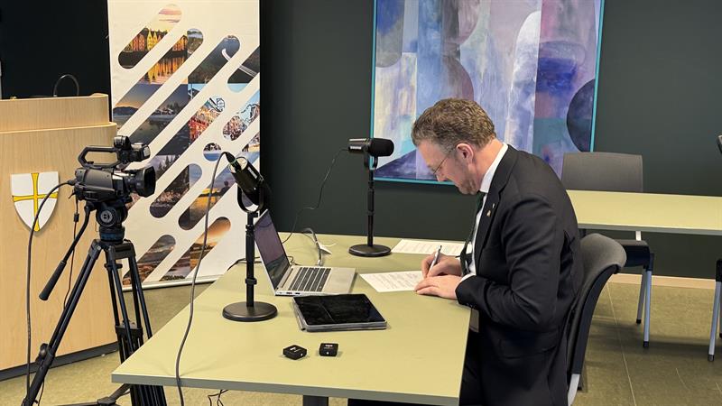 Tomas Iver Hallem signerer avtale. Bilde